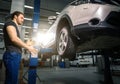 Man preparing for adjusting tire wheel at repair garage Royalty Free Stock Photo