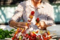 A man preparing barbecue outdoors for friends