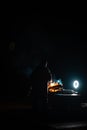 Man preparing bbq grill to cook on fire. Outside dark shot. Freeze moment of fire