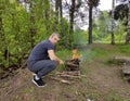 Man preparing bbq sausage in a mangal. Fresh juicy shish sausages fried on coals on a barbecue grid in forest, in nature. Royalty Free Stock Photo