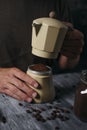 Man preparing coffee in a beige moka pot