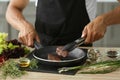 Man preparing delicious meat with fresh spices in kitchen