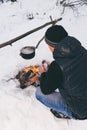 Winter camping, man warm up hands. Boiling water in pot. Wilderness and snow. Witnter time Royalty Free Stock Photo