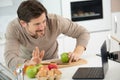 man preparing fruit while waving to laptop screen Royalty Free Stock Photo