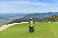 A man is preparing for a paragliding jump and waiting for the right wind. Parachuting from a mountain surface Royalty Free Stock Photo