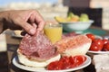 Man preparing a salami sandwich