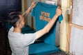 Male Asian worker holding T-shirt printing