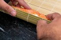 Man preparing sushi at home, a homemade gourmet salmon roll Royalty Free Stock Photo