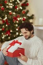 Man With Present in the Gift Box Near Christmas Tree at Home Royalty Free Stock Photo