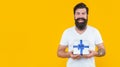 man with present isolated on yellow background, copy space. present box for man in shirt.