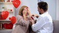 Man presenting beloved lady with closed eyes precious ring, proposal marriage Royalty Free Stock Photo