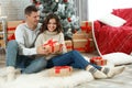 Man presenting Christmas gift to girlfriend at home