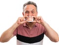 Man presenting fake teeth covering mouth cheerful expression