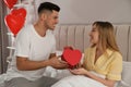 Man presenting gift to his girlfriend at home in morning. Valentine`s day celebration Royalty Free Stock Photo