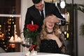 Man presenting roses to his beloved woman in restaurant at Valentine`s day