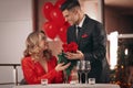 Man presenting roses to his beloved woman in restaurant at Valentine`s day dinner