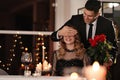 Man presenting roses to his beloved woman in restaurant at Valentine`s day dinner