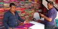 Man presenting sari to the male customer in showroom