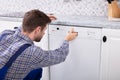 Man Pressing Button Of Dishwasher Royalty Free Stock Photo
