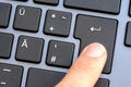 Man pressing the enter key on a black laptop keyboard, finger closeup, completion, sending a message when chatting, confirming a Royalty Free Stock Photo