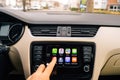 Man pressing Now Playing button on the Apple CarPlay main screen