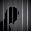Man in a prison behind jail bars silhouette