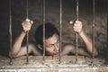 Man in prison hands of behind hold Steel cage jail bars, Male p