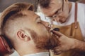 Man in the process of trimming a beard in a barbershop Royalty Free Stock Photo