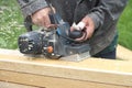 The man processes a board a electric planer outdoors Royalty Free Stock Photo