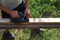 Man processes a board with an electric planer on the street Royalty Free Stock Photo