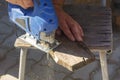 A man processes wood with an electric jigsaw. A carpenter sawing a board with a blue electric jigsaw Royalty Free Stock Photo