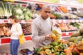 Man in produce section of supermarket choosing sweet paper and bananas Royalty Free Stock Photo