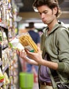 Man, product and comparison choice in supermarket for label difference, nutrition value or grocery shopping. Male person