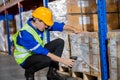 man professional worker wearing safety uniform and hard hat worker scanning box inspect product on shelves in warehouse