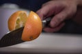 A man professionally cuts a orange