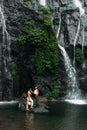 A man proposes to a woman at a waterfall. A guy proposes to a girl in Bali. Offer of a hand in travel. Honeymoon trip.