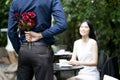 A man is proposing marriage to a smiling woman with a lovely flower bouquet in a beautiful garden Royalty Free Stock Photo