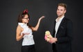 Man proposing with Valentines bear to angry girl in red devil horns dark background, Halloween Royalty Free Stock Photo