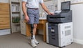 Man with prosthetic leg using office printer Royalty Free Stock Photo