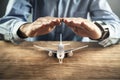 Man protect toy airplane. Travel insurance Royalty Free Stock Photo