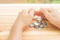 Man protecting house model on table, planning savings money of coins to buy a home Royalty Free Stock Photo