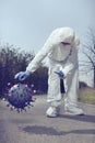 Specialist fighting with model of coronavirus virion outdoor on sidewalk