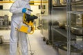 man in protective equipment disinfects with spray gun industrial kitchen coronavirus covid-19 Royalty Free Stock Photo