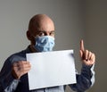 Man in protective face mask with white blank sheet poster mockup