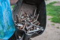 Man with protective gloves holding the box with metal bolt and nuts