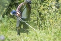 Man with protective headwear and goggles trimming the lawn Royalty Free Stock Photo