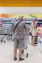A man with a protective mask chooses a product in a department store