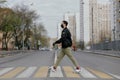 A man in a protective mask crosses the road at a pedestrian crossing Royalty Free Stock Photo