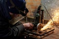 A man in a protective mask cuts metal on a machine tool