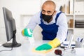 Man in protective mask and in an overalls cleans the table Royalty Free Stock Photo